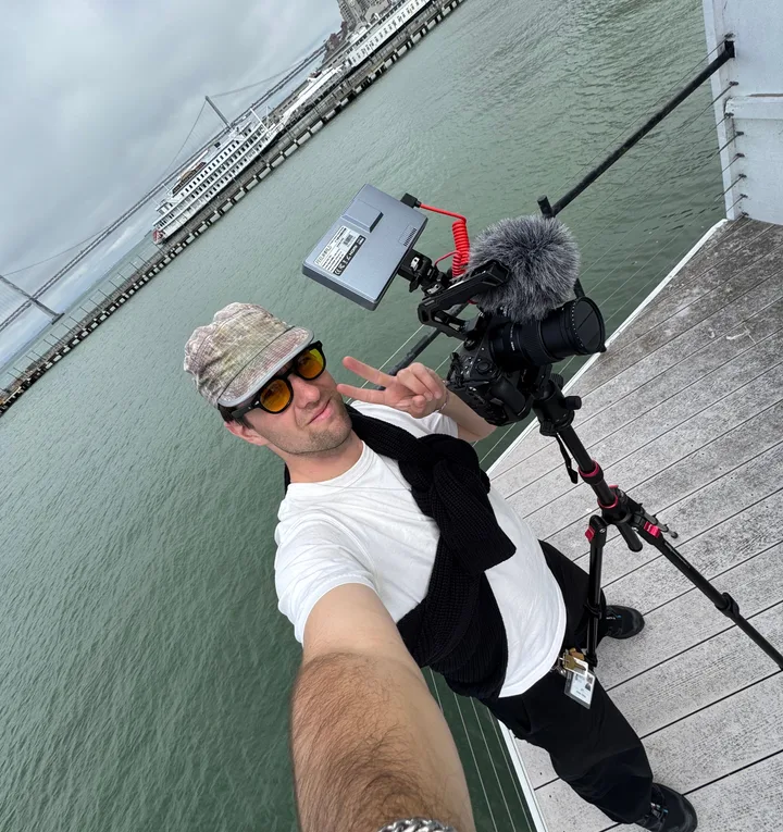 Graeme filming on a pier on the San Francisco waterfront, his camera on a tripod beside him